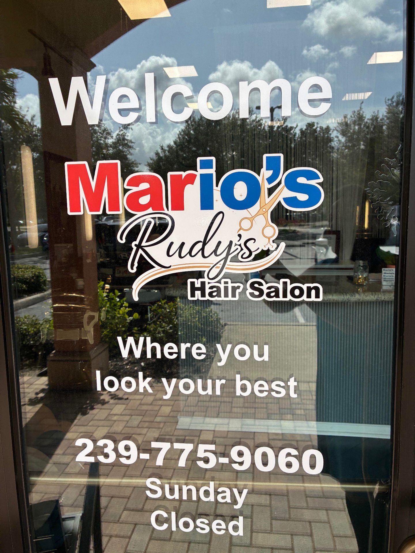 Front door of Mario's Rudy's Hair Salon with the welcome logo decal